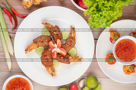 Shrimp wrapped pork cutlets arranged beautifully with cucumbers and tomatoes in a beautiful white dish. Стоковое фото, агентство Ingram Publishing / Фотобанк Лори