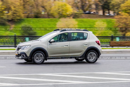 Side view rolling shot with Dacia Sandero Stepway subcompact car. Fast moving beige small hatchback with motion blur effect. Редакционное фото, фотограф Константин Григорьев / Фотобанк Лори
