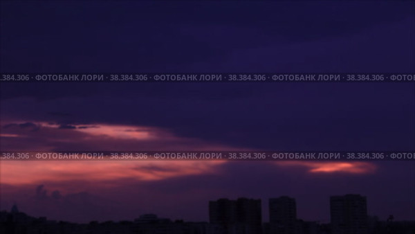 Силуэты многоэтажных домов в городе на фоне багрового сумеречного неба заполняемого темными облаками. Стоковое видео, видеограф Цыбин Вадим / Фотобанк Лори