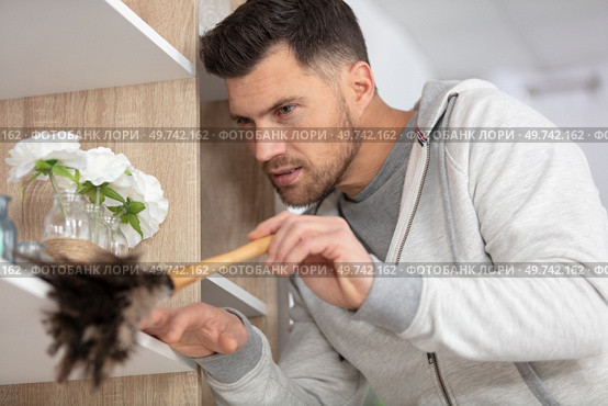 single man dusting his furnitures. Стоковое фото, агентство Ingram Publishing / Фотобанк Лори