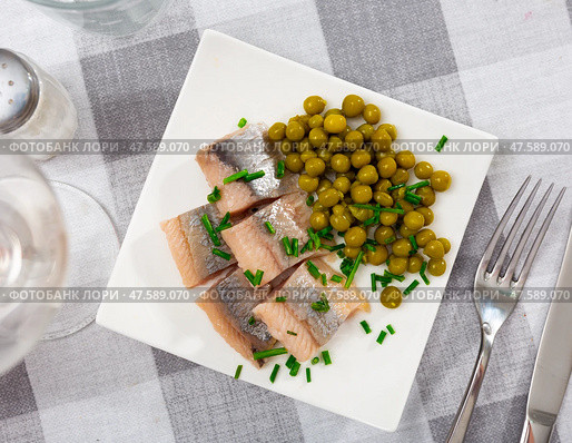 Sliced herring served with scallion and peas on table. Стоковое фото, фотограф Яков Филимонов / Фотобанк Лори