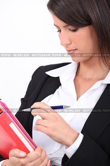 Smart woman ticking something off a file. Стоковое фото, агентство Ingram Publishing / Фотобанк Лори
