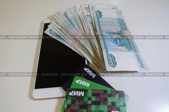 Смартфон, телефон, мобильник на фоне денег и банковских карт. Smartphone, phone, mobile on the background of money and bank cards. (2024 год). Редакционное фото, фотограф Юрий Пуликов / Фотобанк Лори
