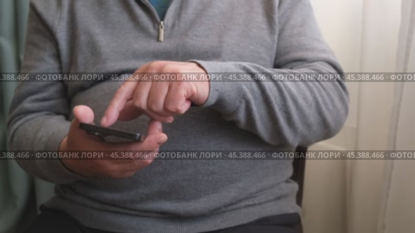 Смартфон в руках у пожилого мужчины. Пенсионер использует смартфон. Стоковое видео, видеограф Терехова Марина / Фотобанк Лори