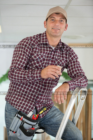 smile man posing near ladder. Стоковое фото, агентство Ingram Publishing / Фотобанк Лори