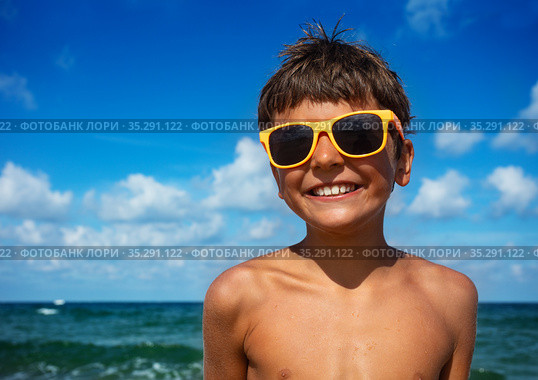 Smiling boy in sunglasses with sea on background. Стоковое фото, фотограф Сергей Новиков / Фотобанк Лори