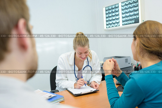 smily young female doctor giving results to patients. Стоковое фото, агентство Ingram Publishing / Фотобанк Лори