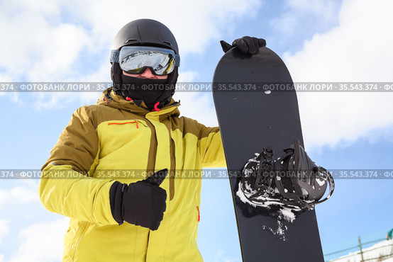 Snowboard and snowboarder with thumb up. Man wearing helmet, goggles and gloves. Extreme winter sport. Стоковое фото, фотограф Кекяляйнен Андрей / Фотобанк Лори