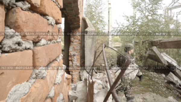 Солдат с оружием выходит из разрушенного здания. Стоковое видео, видеограф Сергей Елизаров / Фотобанк Лори