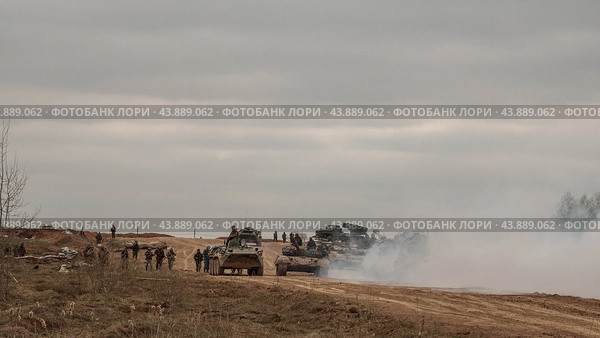 Солдаты и военная техника на пустынной земляной дороге. Танк, бтр, рсзо движутся на позицию. Армия России. (2019 год). Редакционное фото, фотограф Евгений Зимин / Фотобанк Лори