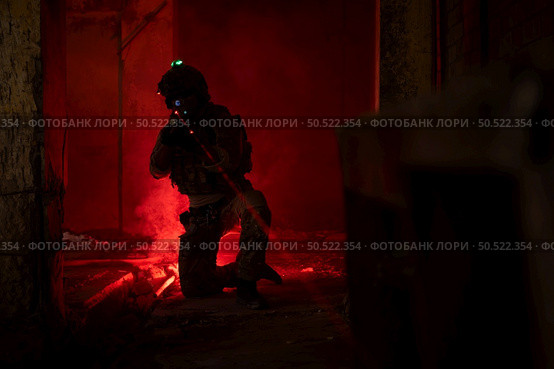 Soldier in anti-terrorist warfare in a dark building, Anti-terrorist operation training on the battlefield. Стоковое фото, агентство Ingram Publishing / Фотобанк Лори