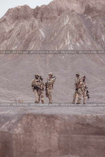 Soldiers in camouflage military uniforms carrying weapons, Reconnaissance missions in rugged mountains, Assault infantry battle training. Стоковое фото, агентство Ingram Publishing / Фотобанк Лори