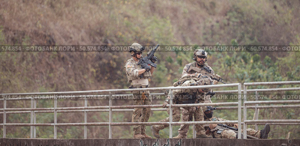 Soldiers in camouflage military uniforms carrying weapons, Reconnaissance missions in the tropical forest area, Assault infantry battle training. Стоковое фото, агентство Ingram Publishing / Фотобанк Лори