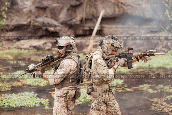 Soldiers in camouflage military uniforms carrying weapons, Reconnaissance missions in the tropical forest area, Assault infantry battle training. Стоковое фото, агентство Ingram Publishing / Фотобанк Лори