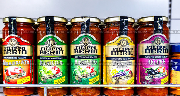 Соусы Filippo Berio в стеклянных банках на полке супермаркета. Редакционное фото, фотограф FotograFF / Фотобанк Лори