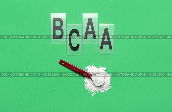 Совок аминокислотной добавки и буквы BCAA на зеленом фоне. Стоковое фото, фотограф Pixel_shot / Фотобанк Лори
