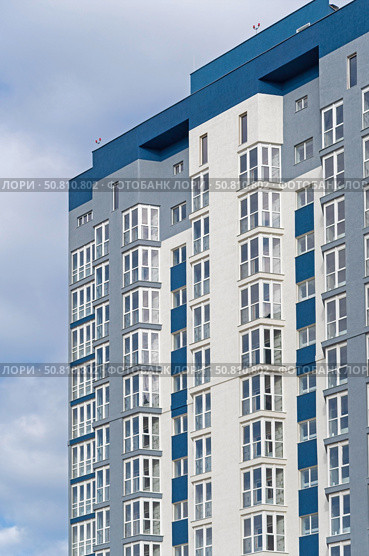 Современный многоэтажный красивый дом на фоне голубого неба. Modern panel apartment building on background of blue sky. Стоковое фото, фотограф Татьяна Д / Фотобанк Лори