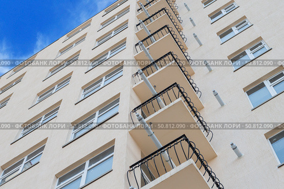 Современный многоэтажный красивый дом на фоне голубого неба. Modern panel apartment building on background of blue sky. Стоковое фото, фотограф Татьяна Д / Фотобанк Лори