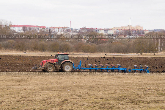 Современный трактор пашет землю многокорпусным плугом (2023 год). Редакционное фото, фотограф Дмитрий Сакретарев / Фотобанк Лори