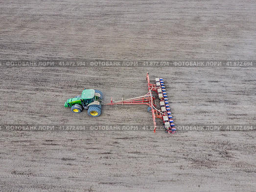 Sowing of corn. Tractor with a seeder on the field. Using a seeder for planting corn. Стоковое фото, фотограф Леонид Еремейчук / Фотобанк Лори