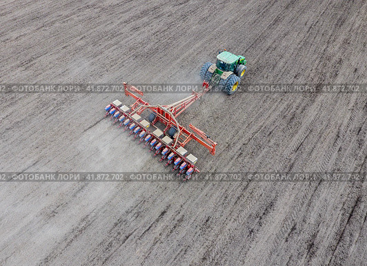 Sowing of corn. Tractor with a seeder on the field. Using a seeder for planting corn. Стоковое фото, фотограф Леонид Еремейчук / Фотобанк Лори
