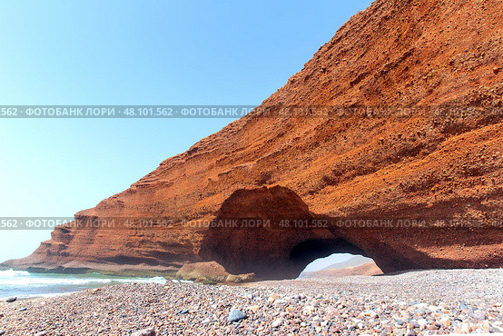 Spectacular natural red arch on atlantic ocean coast, Legzira (or Gzira) beach. Red archs on atlantic ocean coast. Sidi Ifni, Morocco, Africa (2024 год). Стоковое фото, фотограф Евгений Ткачёв / Фотобанк Лори