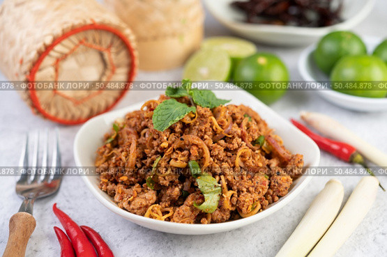 Spicy pork chops in a white dish consisting of lemons, chilies, and side dishes. Selective focus. Стоковое фото, агентство Ingram Publishing / Фотобанк Лори