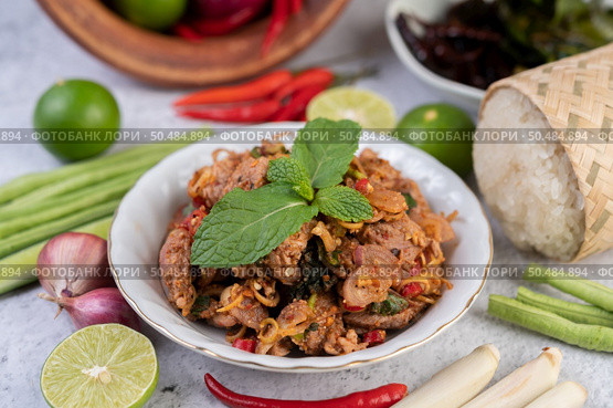 Spicy pork chops in a white dish consisting of lemons, chilies, and side dishes. Selective focus. Стоковое фото, агентство Ingram Publishing / Фотобанк Лори