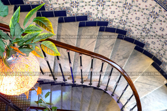 Spiral staircase. Top view. Chandelier and ceramic tiles on the wall. Стоковое фото, фотограф Евгений Ткачёв / Фотобанк Лори