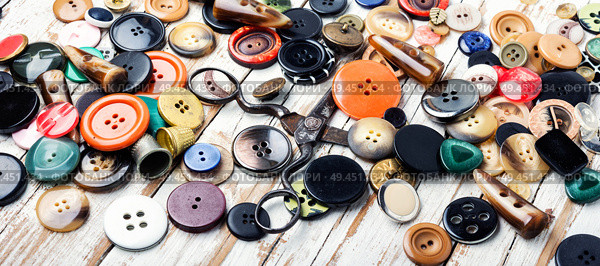 Spools of threads and buttons on wooden table.Needlework and tailoring concept. Various sewing buttons and thread. Стоковое фото, агентство Ingram Publishing / Фотобанк Лори