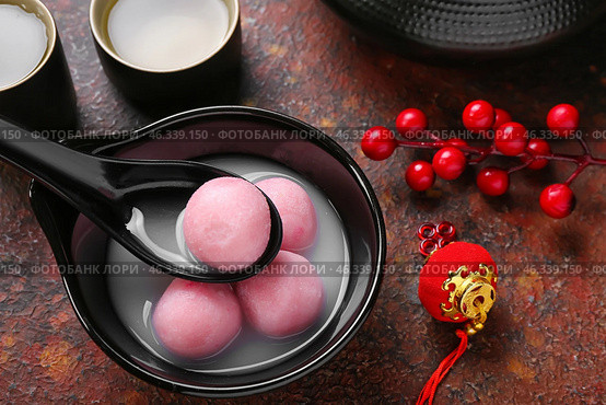 Spoon and bowl of tangyuan with Chinese decor on grunge background, closeup. Dongzhi Festival. Стоковое фото, фотограф Pixel_shot / Фотобанк Лори