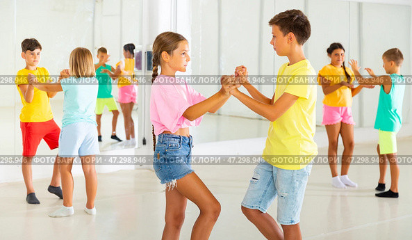 Sporty preteen children learning to dance vigorous jive in pairs. Стоковое фото, фотограф Яков Филимонов / Фотобанк Лори