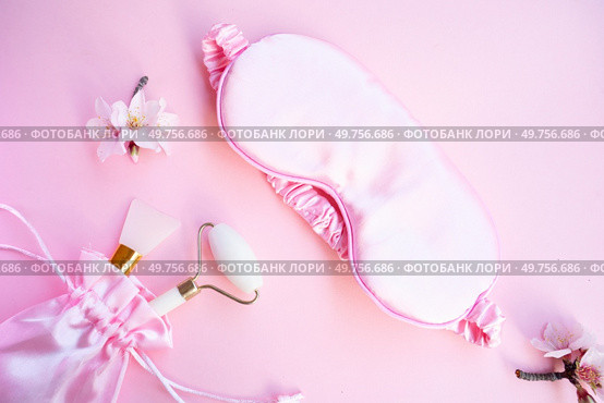 spring flowers with sleeping mask and gua sha massager, sleep-wake disorders concept, insomnia therapy, sleep difficulties and deprivation. spring flowers with sleeping mask, sleep-wake disorders. Стоковое фото, агентство Ingram Publishing / Фотобанк Лори