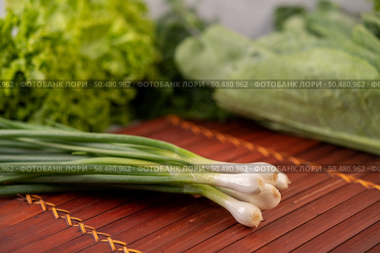 Spring onions placed on a wooden plate. Selective focus. Стоковое фото, агентство Ingram Publishing / Фотобанк Лори
