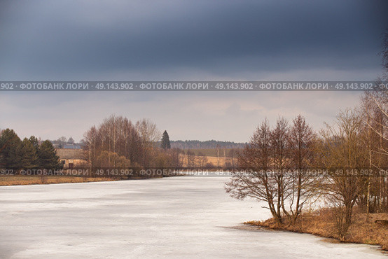 Spring rural scene. Lake under ice and snow melting. Cloudy spring day. Early spring. Mud season. Стоковое фото, агентство Ingram Publishing / Фотобанк Лори