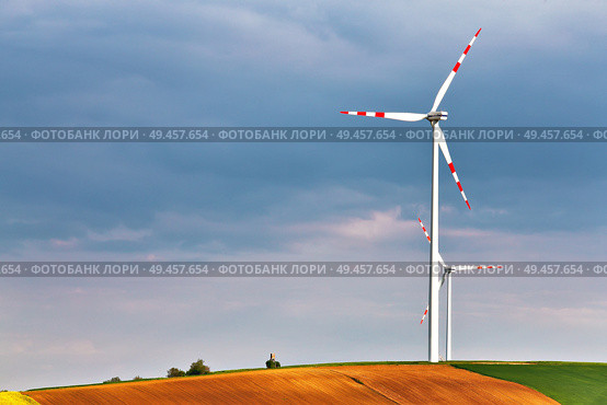 Spring sunny day, green fields with wind power generators. Eco power. Wind turbines park generating electricity. Hunting box on top of the hill. Lower Austria near Poysdorf. Стоковое фото, агентство Ingram Publishing / Фотобанк Лори