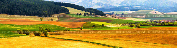 Spring tillage on hills panorama. Picturesque ploughland in a valley in Tatras mountains of Slovakia. Rural scene of cultivated land. . Стоковое фото, агентство Ingram Publishing / Фотобанк Лори