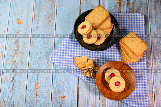 Stack many types of cookies on a plate and put on a wooden table. Стоковое фото, агентство Ingram Publishing / Фотобанк Лори