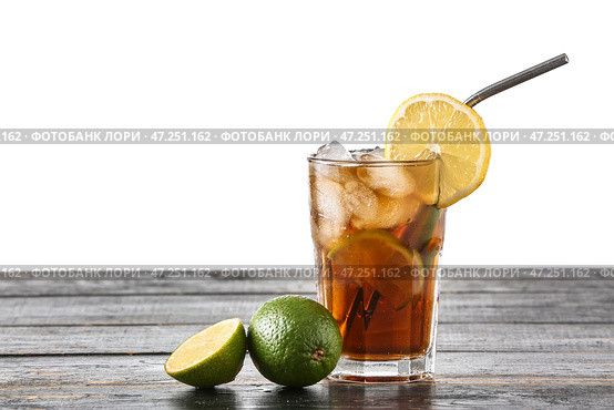 Стакан вкусного коктейля Cuba Libre на столе на белом фоне. Стоковое фото, фотограф Pixel_shot / Фотобанк Лори