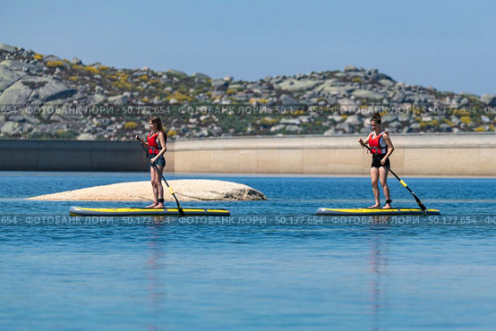 Stand up paddleboarding on lake. Watersport on lake. Tourist outdoor activity at Lagoa Comprida, Serra da Estrela National Park in Portugal. Стоковое фото, агентство Ingram Publishing / Фотобанк Лори
