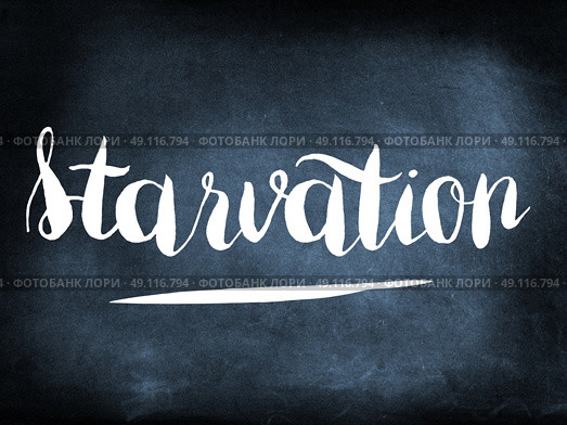 Starvation handwritten on a chalkboard. Стоковое фото, агентство Ingram Publishing / Фотобанк Лори