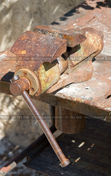 Старые тиски закрепленные на верстаке. An old vise fixed on a workbench. Стоковое фото, фотограф Татьяна Д / Фотобанк Лори