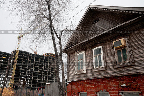Старый  дом времен Российской империи в исторической части старого города Астрахань ( Южная часть города ). Со всех сторон надвигаются новостройки, и он обречен на снос (2018 год). Стоковое фото, фотограф Павел Просянов / Фотобанк Лори