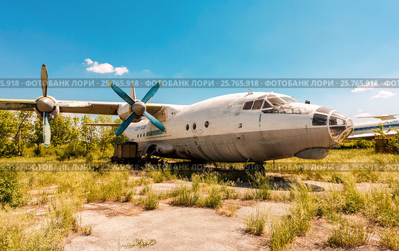 Старый самолет Ан-12 на заброшенном аэродроме в летний солнечный день. Редакционное фото, фотограф FotograFF / Фотобанк Лори