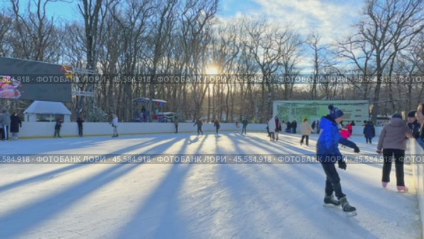 Ставрополь, парк Победы - Люди катаются на коньках на открытом катке в городском парке. Зимний городской пейзаж с толпой людей на открытом катке. Новогодние и Рождественские каникулы. Редакционное видео, видеограф Ирина Михайличенко / Фотобанк Лори
