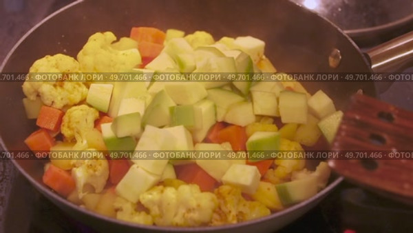 Stir fry with fresh cauliflower, carrots, and potatoes in a black pan. Стоковое видео, видеограф Татьяна Лобанова / Фотобанк Лори