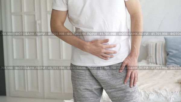 Stomach ache, man with abdominal pain suffering at home, health problems concept. Стоковое видео, видеограф Станислав Тарко / Фотобанк Лори