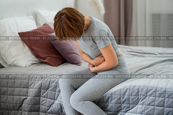 Stomach ache, symptoms of gastritis or pancreatitis, woman with abdominal pain suffering at home. Стоковое фото, фотограф Станислав Тарко / Фотобанк Лори