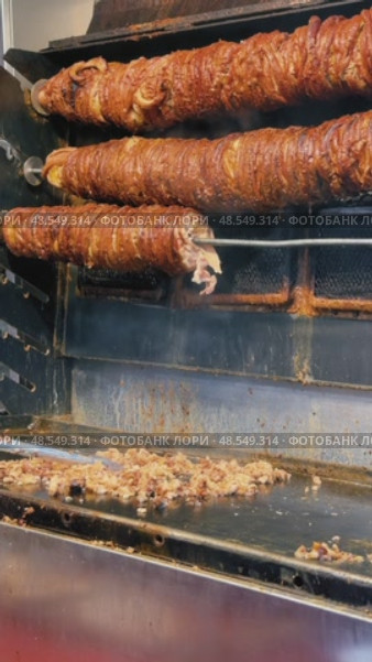 Street food vendor slicing and grilling traditional Turkish kokorec at a local food stall. Стоковое видео, видеограф Дмитрий Наумов / Фотобанк Лори