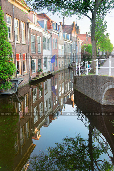street with old houses over canal in Delft old town in Holland. Delft old town in Holland. Стоковое фото, агентство Ingram Publishing / Фотобанк Лори